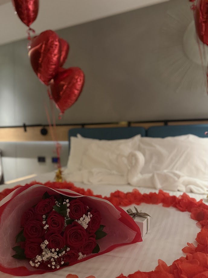 赤いバラ12本の花束と花びらのハート、ハート型バルーンで飾ったプロポーズのお部屋