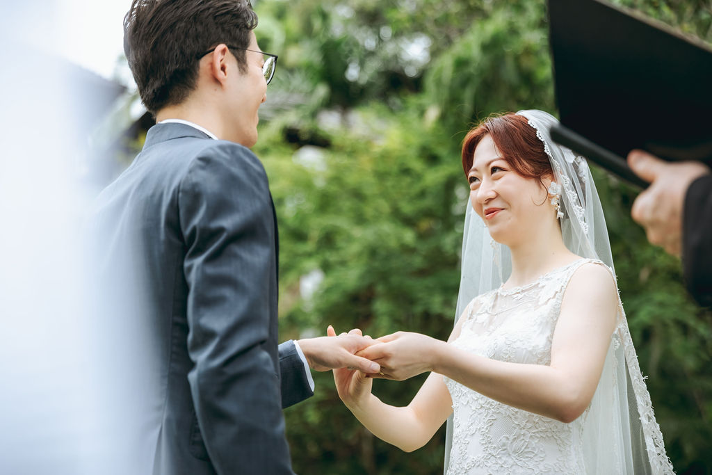 ガーデン挙式で指輪を交換する新郎新婦の手元と笑顔